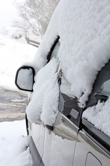 Ein zugeschneites und vereistes Auto im Winter