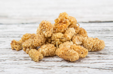 Dried white mulberry over wooden background