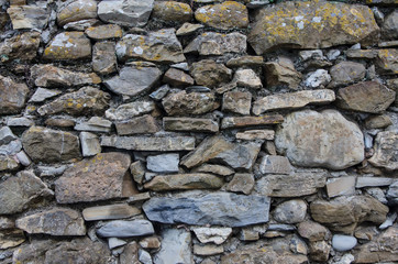 close-up of the weathered  rocks and stones making up an old fence