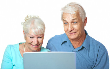  Seniorenpaar hat Spa&szlig; am Laptop, die Frau l&auml;chelt, ihr Mann ist erstaunt und &uuml;berrascht, isoliert auf wei&szlig;em Hintergrund