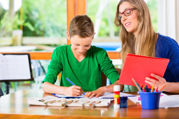 Fototapeta premium Mother helping son with homework assignment