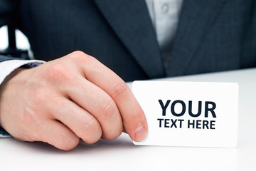 Man's hand showing business card with place for your text.