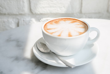 Hot Latte coffee and white wall with sunlight