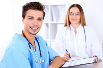 Attractive male doctor near female doctor