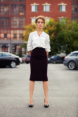 Young fashion business woman standing on the car parking
