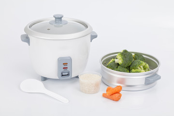 white rice cooker with accessory to cook steamed vegetables