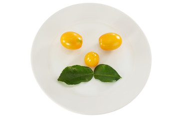 Yellow cherry tomato/Yellow cherry tomato with kaffir lime leaves on white plate.