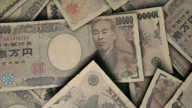 An extreme close up pan of a pile of randomly scattered japanese yen banknotes