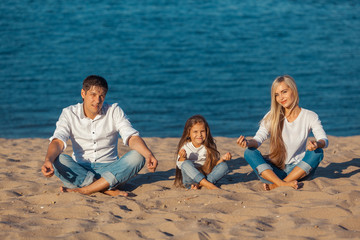 Family at the beach. lotus posture. jeans.