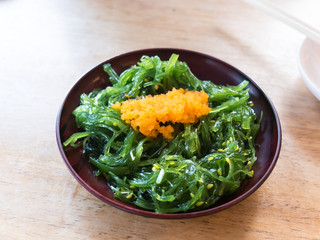 Seaweed salad on wood background