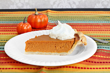 Pumpkin pie slice with whipped cream.