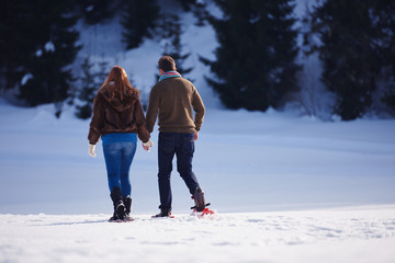 couple having fun and walking in snow shoes