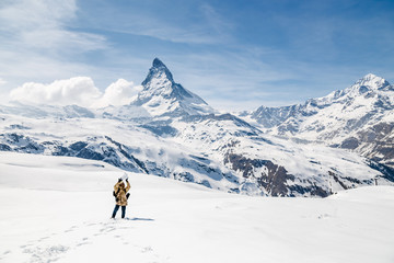 Fototapeta na wymiar A man carry the snow ball with the background of Matterhorn.