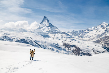 A man celebrate success with the background of Matterhorn.