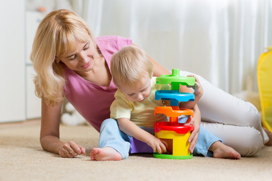 mother and kid playing with colorful logical toy