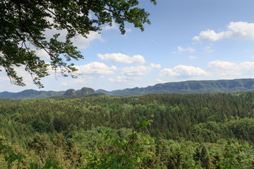 Obraz na płótnie Canvas Panorama with rocks, mountains and forest seen from Kuhstall in Saxon Switzerland
