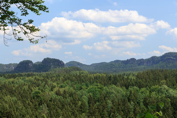 Fototapeta na wymiar Panorama with rocks, mountains and forest seen from Kuhstall in Saxon Switzerland