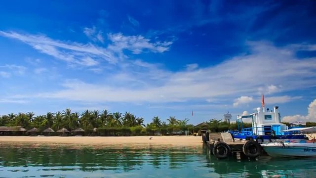 camera moves to pier palm sand beach along azure sea on island