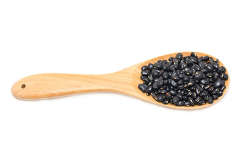 Black beans with wooden spoon isolated on white.