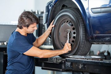 Fototapeta na wymiar Mechanic Fixing Car Tire Wrench