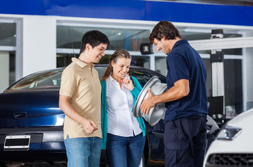 Happy Technician And Couple Looking At Alloy