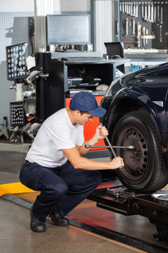 Mechanic Fixing Car Tire At Repair Shop