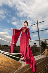Gorgeous woman in vintage clothes on peak-cap of boat