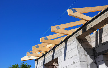 Installation of wooden beams at construction the roof truss system of the house.  Roof Rafters