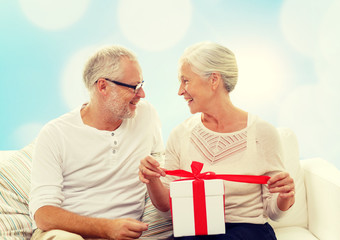 happy senior couple with gift box at home