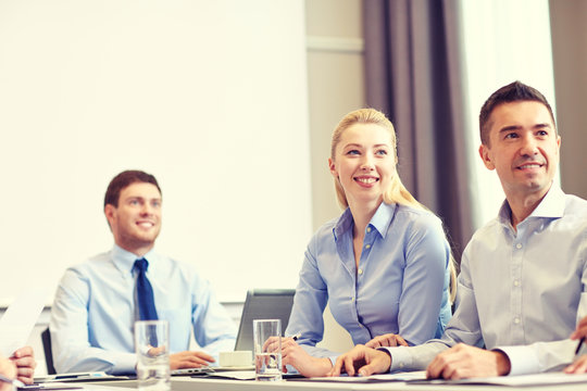 group of smiling businesspeople meeting in office