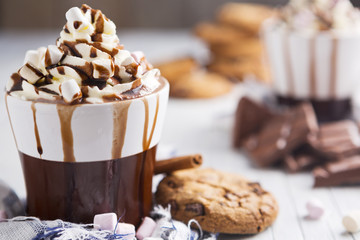Warme chocolademelk, room en marshmallows en een choc-chip cookie
