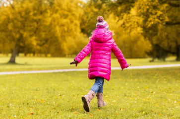 Fototapeta premium happy little girl running in autumn park