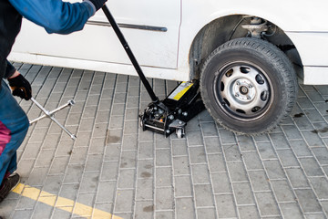 Fototapeta premium mechanic changing a wheel of a modern car (shallow DOF; color to