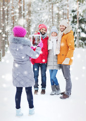 smiling friends with tablet pc in winter forest