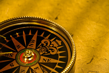 Fototapeta na wymiar Close up view of compass on antiqua paper background