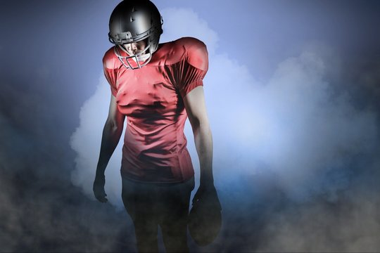 Composite image of american football player looking down