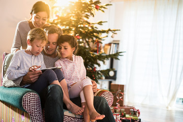 Christmas morning, family having fun with the digital tablet