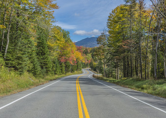 Winding scenic road with autumn colors and mountains.  