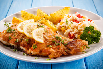 Fish dish - fried fish fillet baked potatoes and vegetables