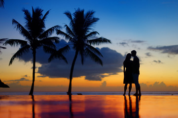 Silhouettes of young couple at scenic sunset