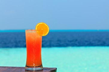 Glass of drink is on a beach table