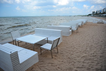 Table chair set beside sea scenic background
