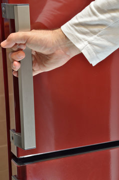 Hand on red refrigerator handle