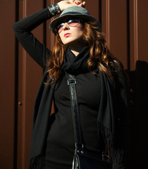 cool  woman wearing sunglasses in autumn dress on brown background