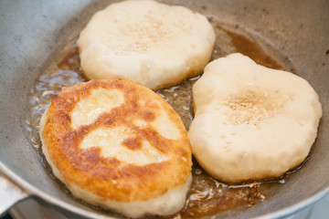 Cooking bhaturas in frying pan