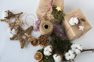 Christmas decorations eco cotton flowers, cinnamon,stars, spruce branches and jute rope hank over white background,holiday,xmas,christmas on white background