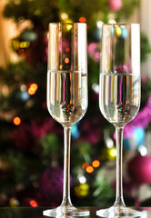two champagner glasses on glass table with bokeh background