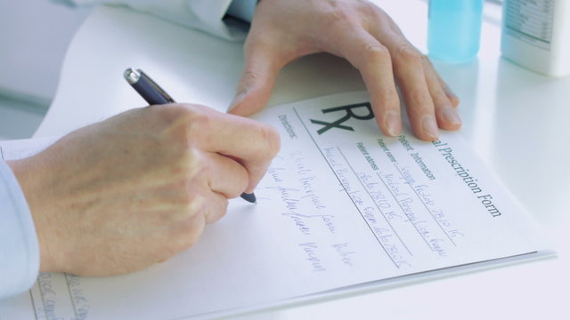 Doctors hand writting rx prescription 