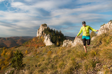 Naklejka na ściany i meble female in skirt running in the mountains on the autumn trail