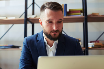 man looking at laptop and working in office